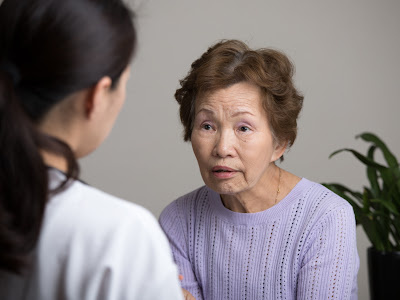 Older woman talking with female healthcare provider